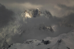 Sommet d'une montagne enneigée qui dépasse de la couche nuageuse