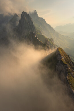 Crête montagneuse baignée de lumière et sortant des nuages